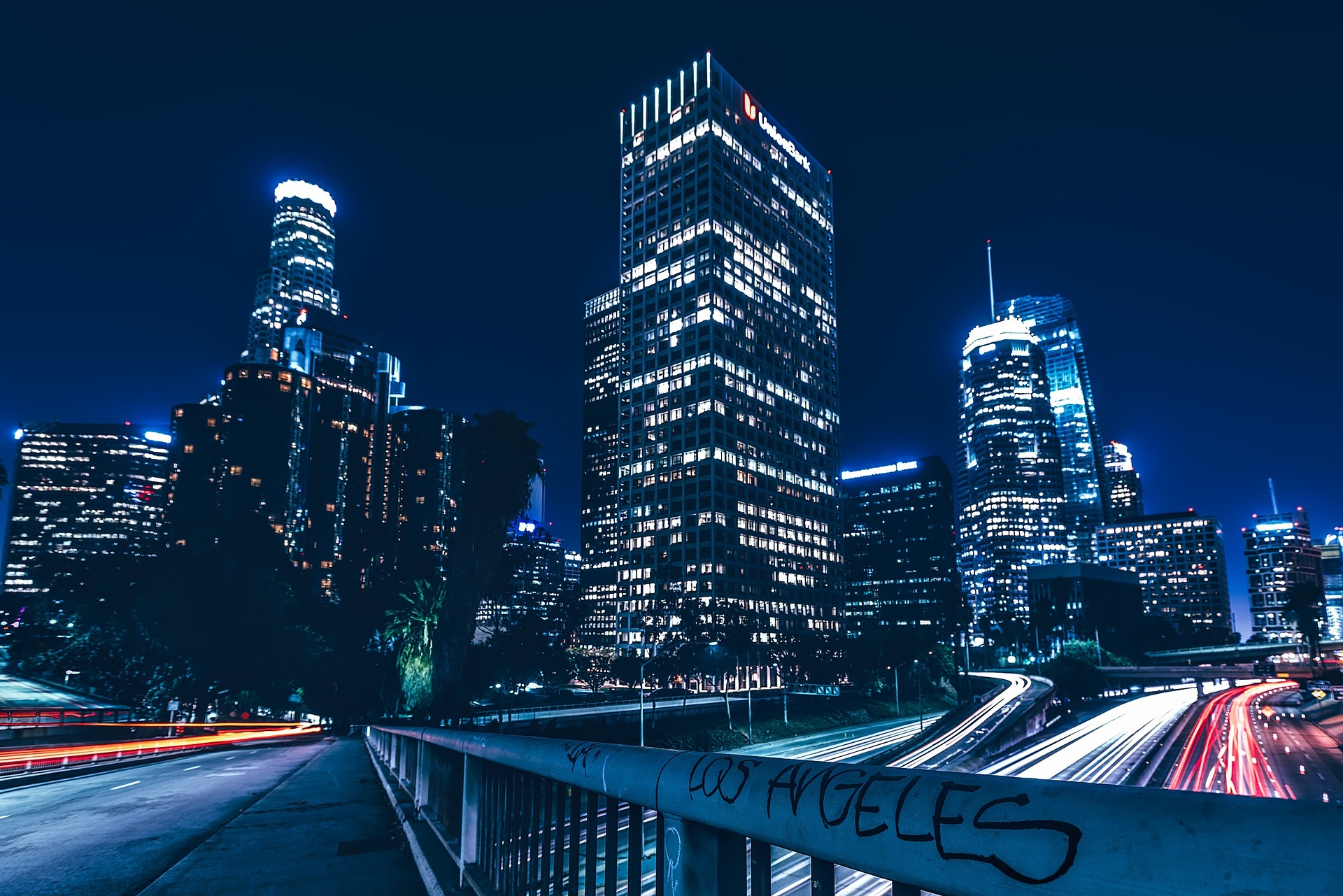 Picture of Los Angeles at night looking up at high rises from a freeway overpass.